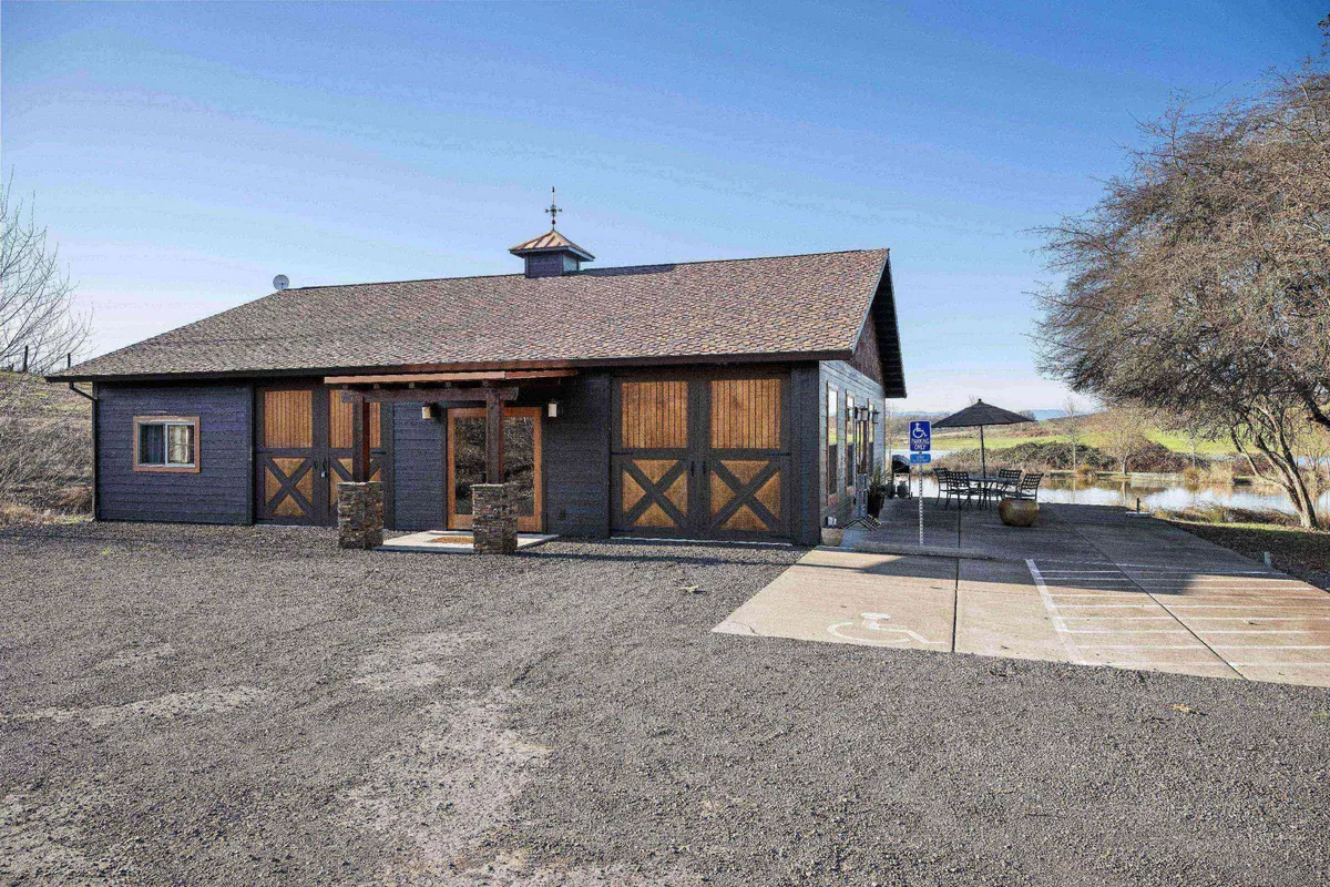 A welcoming exterior view of the home's front entrance, showcasing wooden architectural details, tasteful landscaping, and warm sunset lighting. The space hints at opportunities for outdoor gatherings and relaxation, with inviting areas for guests to mingle.